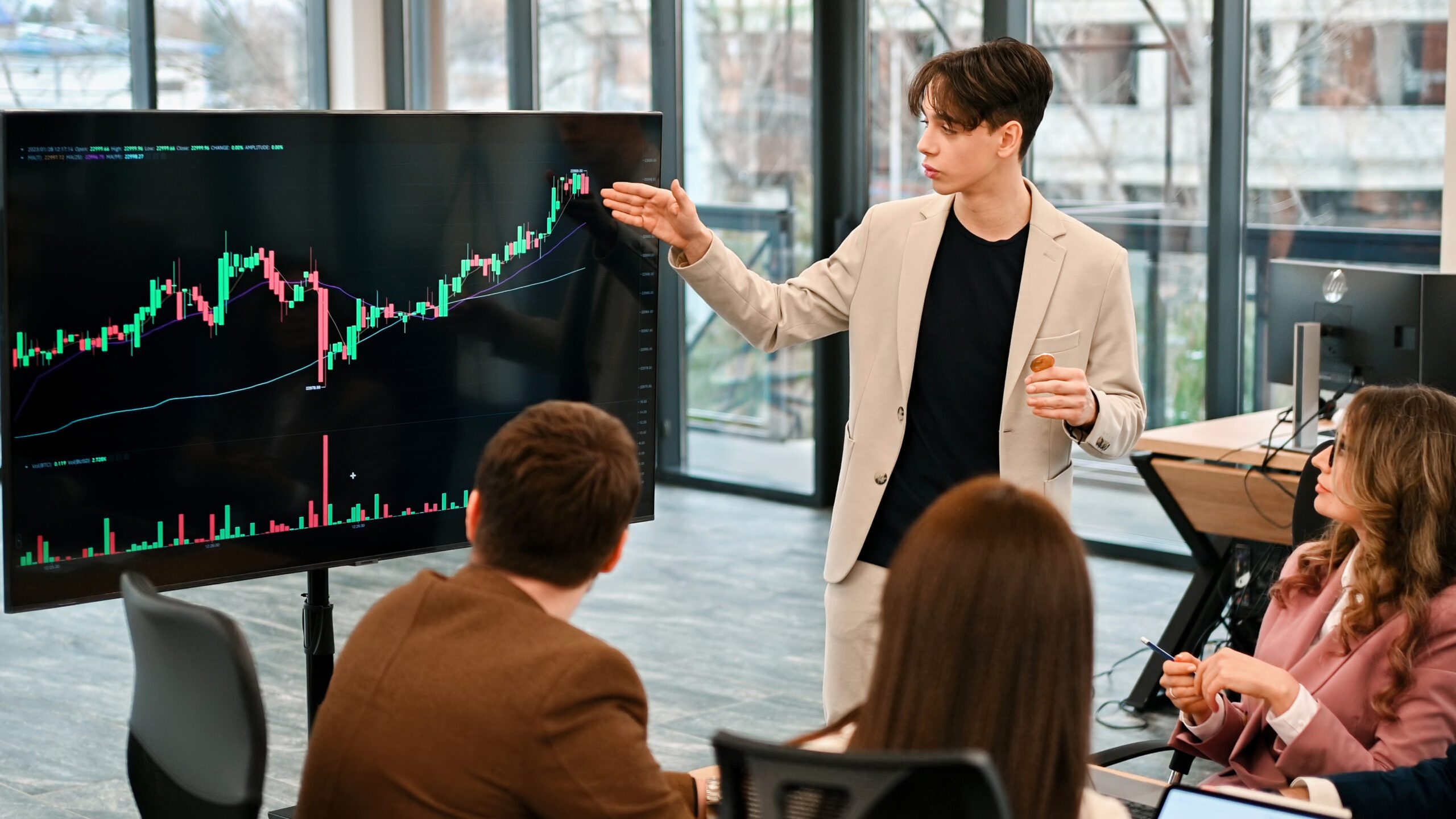 Young worker leading business meeting about cryptocurrencies in an office
